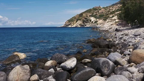 Pebble beach shot with rocks in foreground. Tripod Shot. Stock Footage 93794032