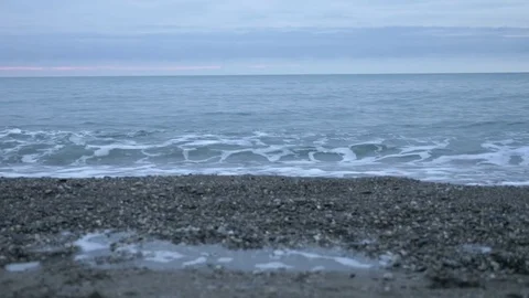 Pebble beach at sunset. The waves splatt... | Stock Video | Pond5