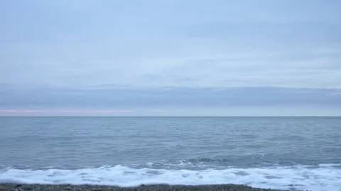 Pebble beach at sunset. The waves splatt... | Stock Video | Pond5