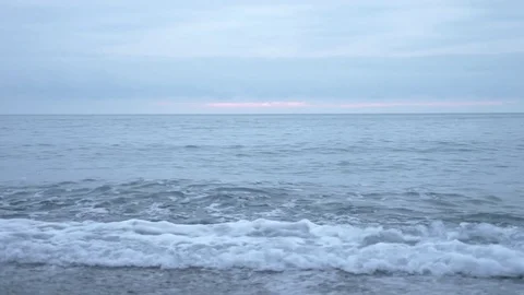 Pebble beach at sunset. The waves splatt... | Stock Video | Pond5