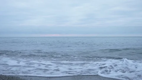 Pebble beach at sunset. The waves splatt... | Stock Video | Pond5