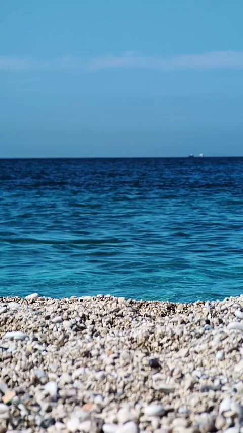 Pebble beach with turquoise sea waves on the Albanian coast Video stock 335636840