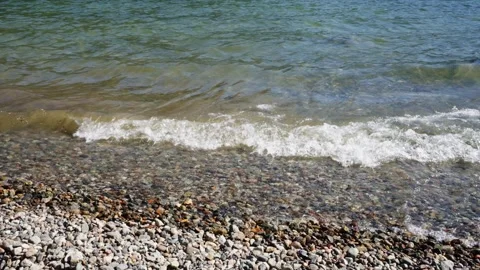Pebble Beach Waves Crashing Gently on Sunny Day Stock Footage 254983074