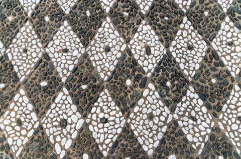 Pebble mosaic forming diamond pattern on outdoor pavement Stock Photos