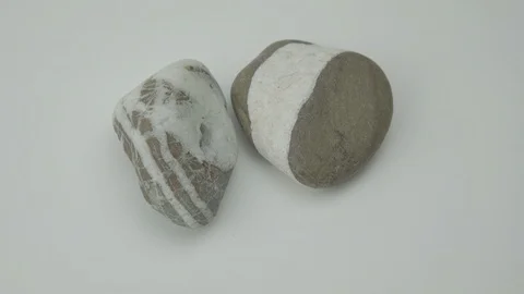 Pebble rocks of grey and white colours lie on light surface Stock Footage 125600005