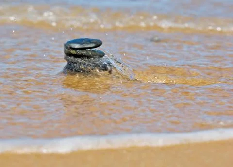 Pebble stack in sea waves Stock Photos
