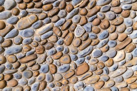 Pebble stone pavement arranged in organic mosaic pattern Stock Photos