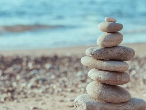 Pebble tower standing on the left on the sea beach Stock Photos