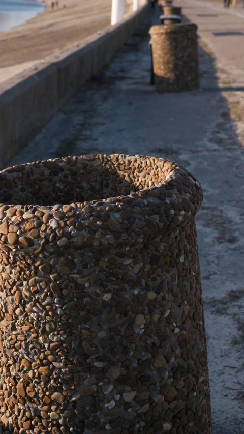 Pebble trash can on a paved seaside promenade in bright sunlight. Video stock 331133833