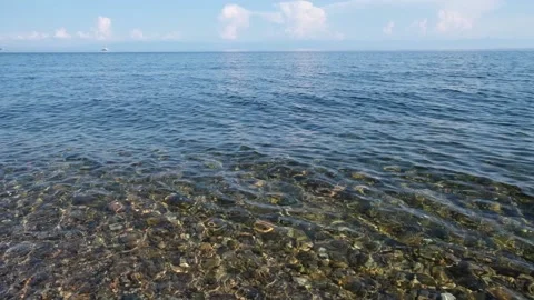 Pebbled lakebed seen through clear rippled lake Baikal transparent water natural Stock Footage