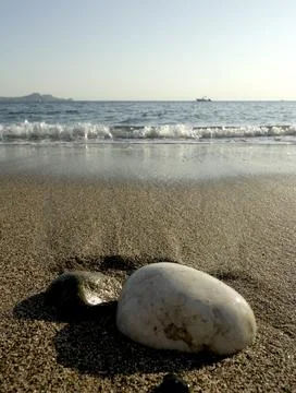 Pebbles on the beach with the sea in the background Stock Photos