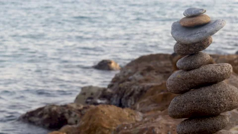 Pebbles big size one over another as pyramid against sea Stock Footage 218812428