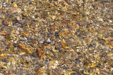 Pebbles at the bottom of the river. Natural background. Stock Photos