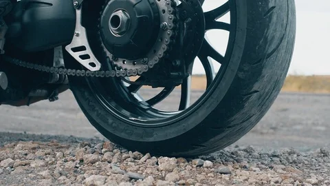 The pebbles bounce off the ground due to the rapid slippage of the motorcycle wh Stock Footage 117420836