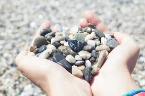 Pebbles in hands, heart pebble shape Stock Photos
