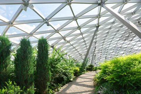 Pebbles path under dome with glass roof, indoor garden with walkway. Stock Photos