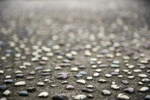 Pebbles pattern on asphalt closeup Stock Photos