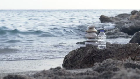 Pebbles in pyramid one over another and bottle with drinking water Stock Footage 222001114