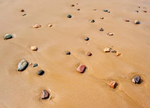 Pebbles in sandy beach Stock Photos