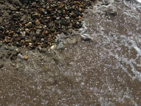 Pebbles on a sandy beach Stock Photos