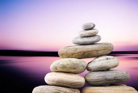 Pebbles stack in peaceful evening with smooth ocean background. zen concept. Stockfoto's