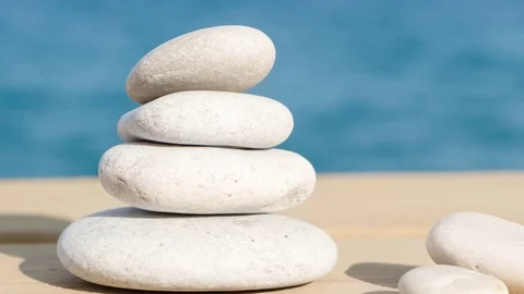 Pebbles stack on the wood pier balance over sea zoom out Stock Footage 75253205