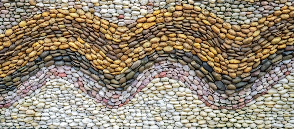 Pebbles stone wall texture background. Pebbles mosaic. Wave pattern design .. 库存照片