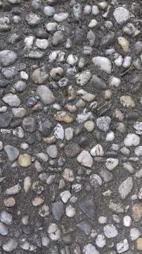 Pebbly pattern background, pebbles embedded in concrete. Stock Photos