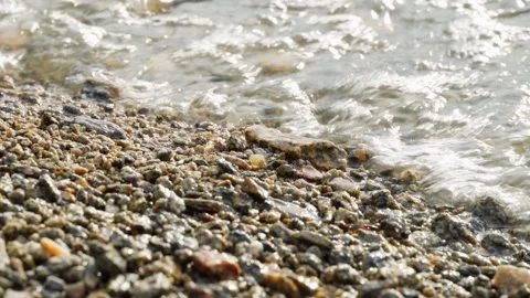The pebbly shore is washed by quiet waves. Close-up. Natural beauty. Stock Footage 275081463