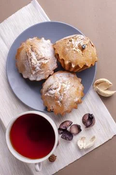 Pecan nut muffins with cup of tea on a plate. Grey background with cupcake. Stock Photos