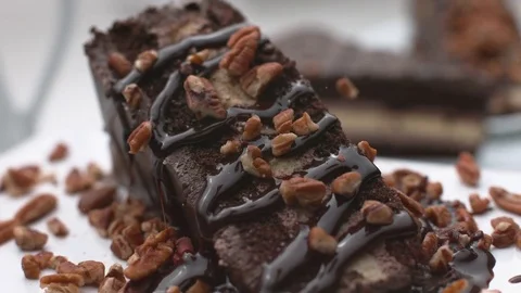 Pecan nuts falling onto chocolate cake in super slow motion, shot on Phantom Stock Footage