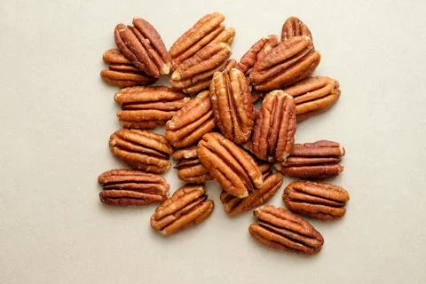 Pecan nuts scattered on a smooth surface create a rustic visual delight Stock Photos