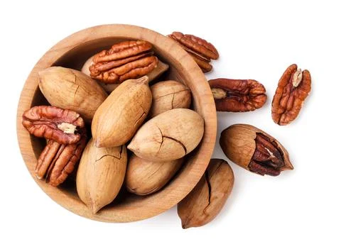 Pecan nuts in shell and peeled in a wooden plate on a white background. Top.. Stock Photos