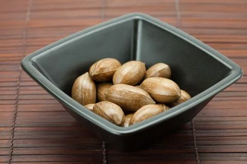 Pecans in a bowl on a bamboo mat Stock Photos