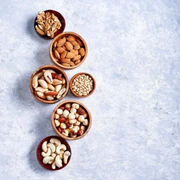 Pecans, hazelnuts, almonds, pine nuts, Brazil nut, cashews in wooden bowls on 库存照片