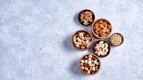 Pecans, hazelnuts, almonds, pine nuts, Brazil nut, cashews in wooden bowls on 库存照片