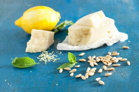 Pecorino cheese, basil, pine nuts and a lemon on a blue surface Foto stock