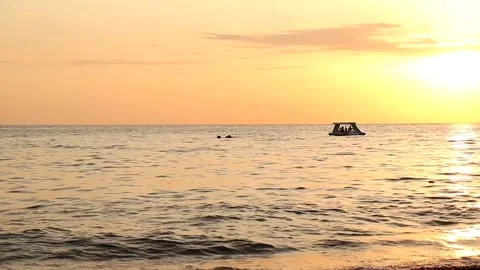 Pedalo swings on the waves at sunset Stock Footage 218980584