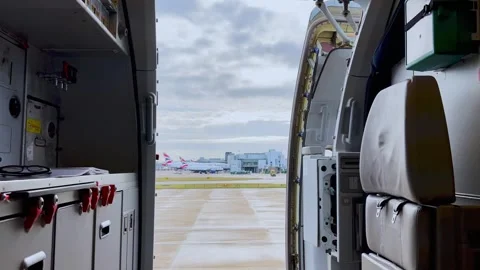 Pedestal down view from inside airplane with open door at gatwick Stock Footage 280706181