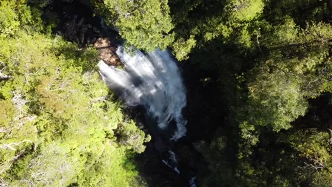 Pedestal drone shot of a waterfall between trees and cliffs in Patagonia, Chile Stock Footage 136065900