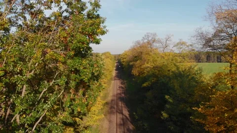 Pedestal shot with tilt down on train tracks with trees and fields sunny day  Stock Footage 134827527