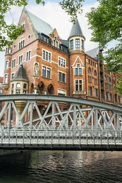 Pedestrian bridge leading between two tall, red brick warehouse buildings i.. Stock Photos