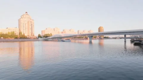 Pedestrian bridge over calm river at golden hour Stock Footage 346572999