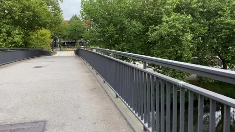 Pedestrian bridge over the Ems River in Rheine, Germany, surrounded by gree.. Stockbeeldmateriaal 346298398