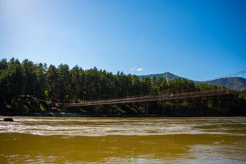 Pedestrian bridge over the Katun river in spring time, Altai, Russia Stock Photos