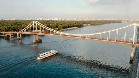 Pedestrian bridge over the river and a boat passing under it, view from above. Stock Footage 236391032