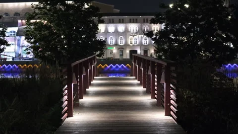 Pedestrian bridge over a small river in the city center at night with Stock Footage 280397193