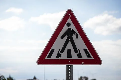 Pedestrian crossing road sign in a triangular shape on a blue sky background Fotos de archivo