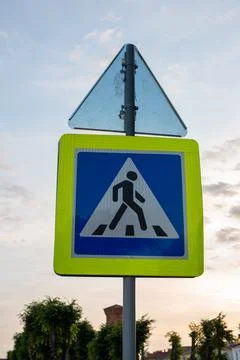 Pedestrian crossing sign with triangular warning sign above. Yellow border Stock Photos