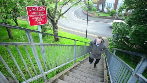 Pedestrian passing warning sign of steep and uneven steps united kingdom Stock Footage 171323331